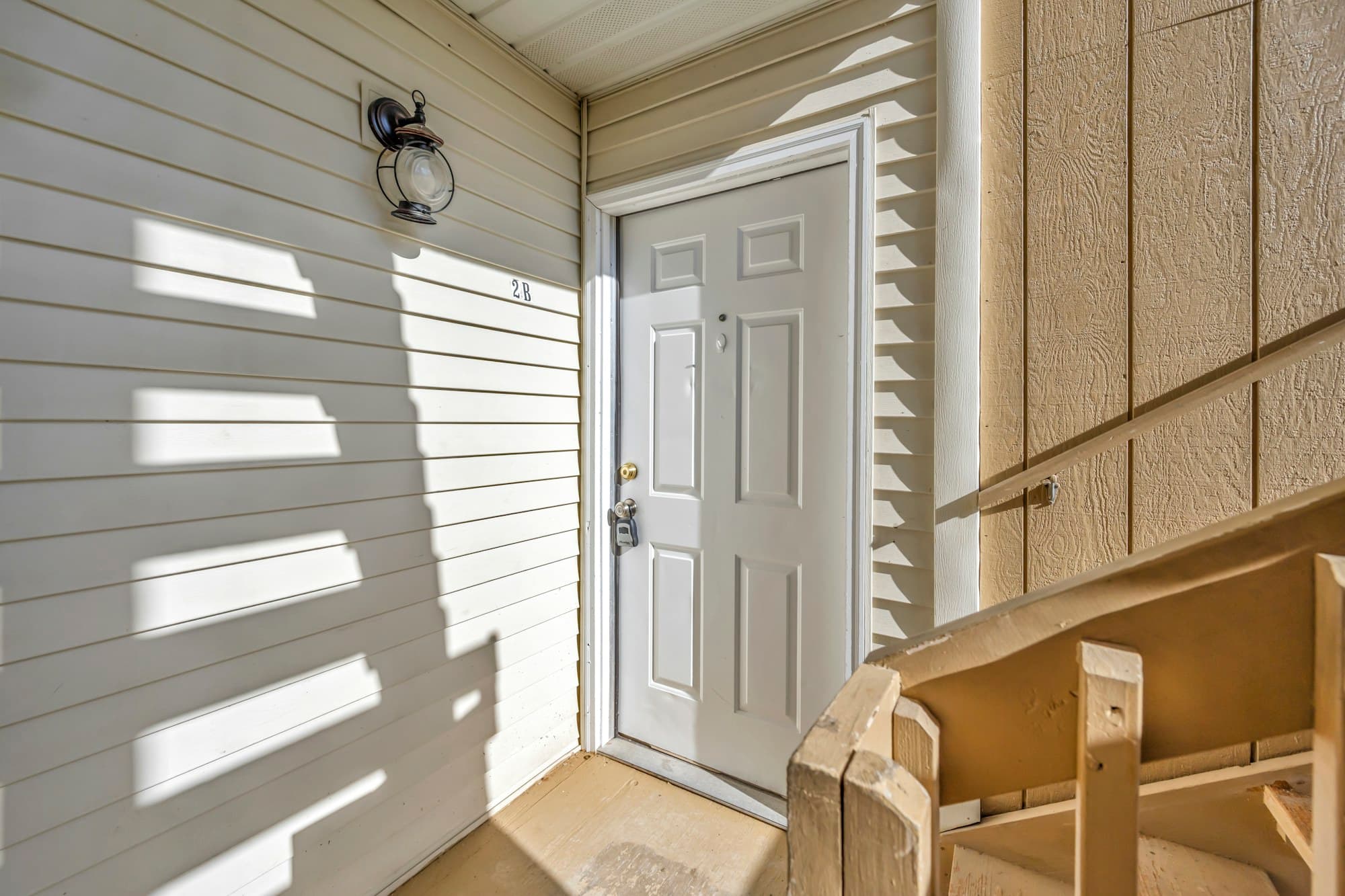 The white front door of a house in sunlight