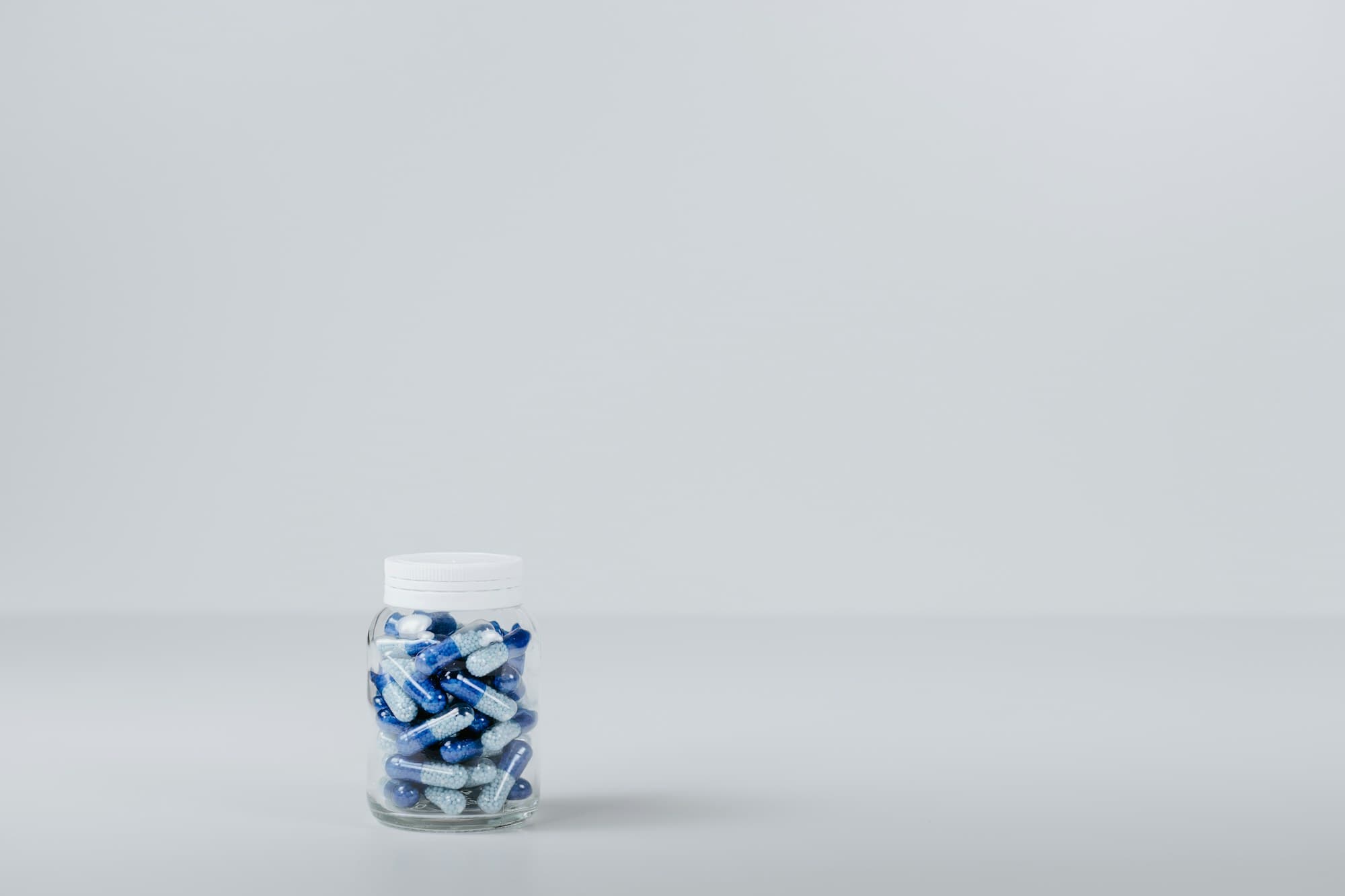 A small bottle of capsules on a pale surface