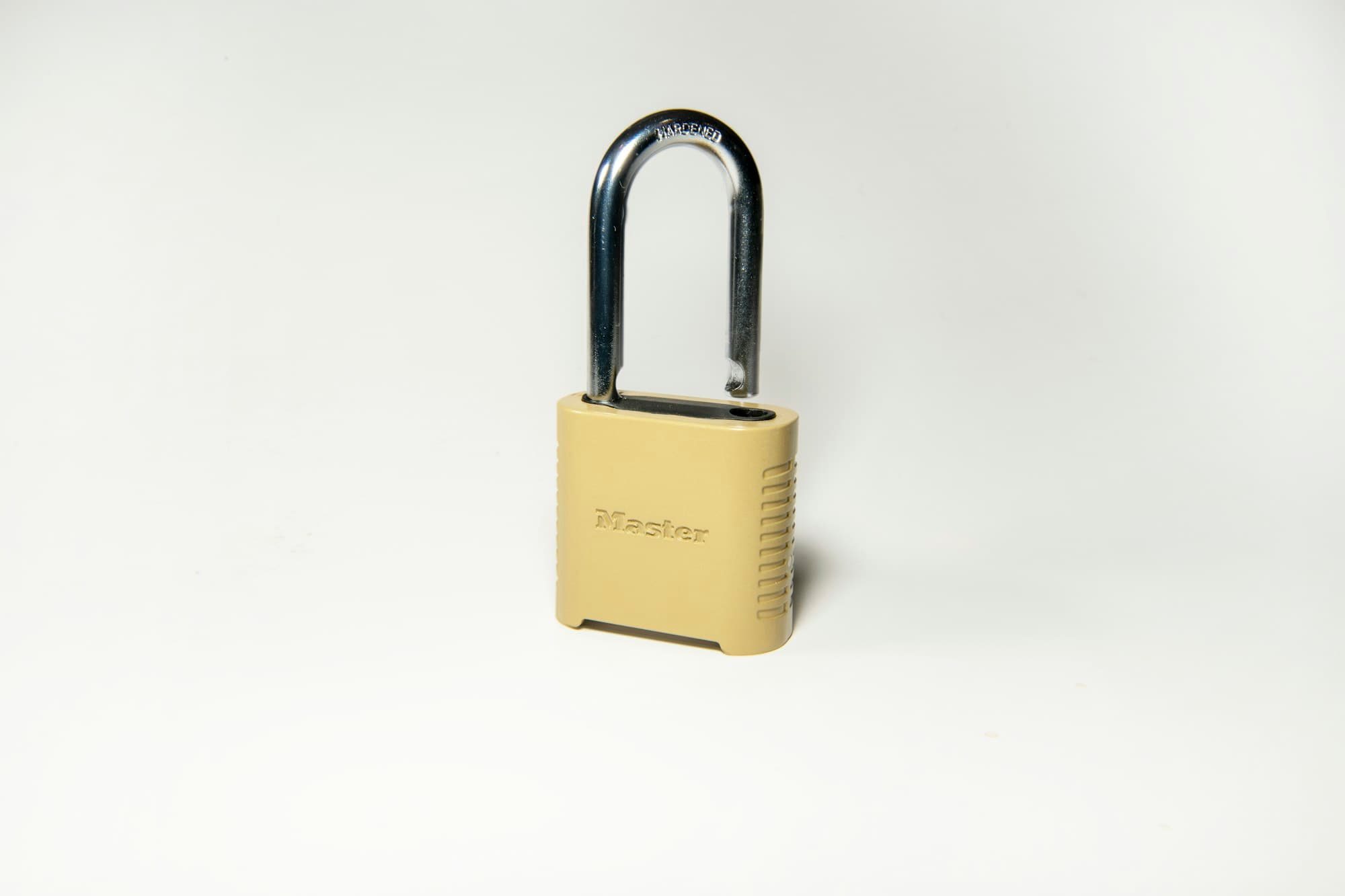 A brass padlock on a white surface