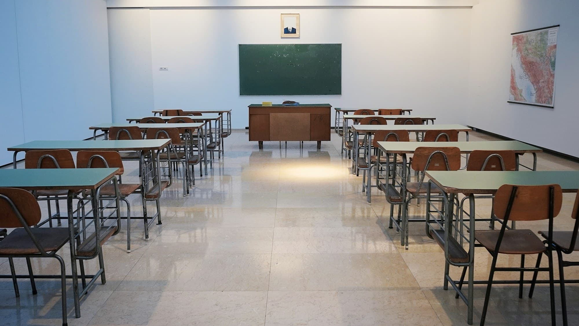 An empty, sunlit classroom with rows of desks