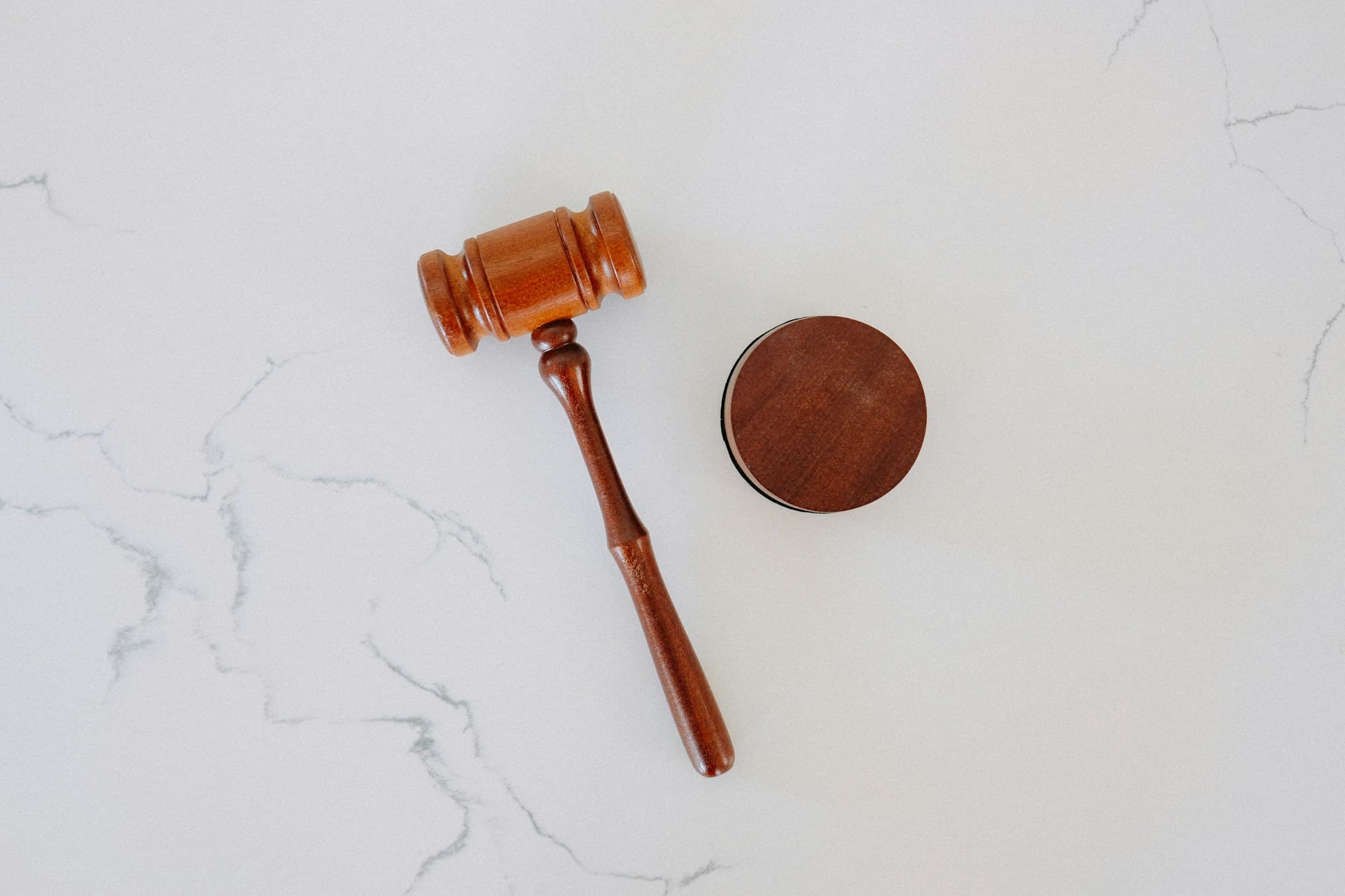 A wooden gavel and sound block on marble